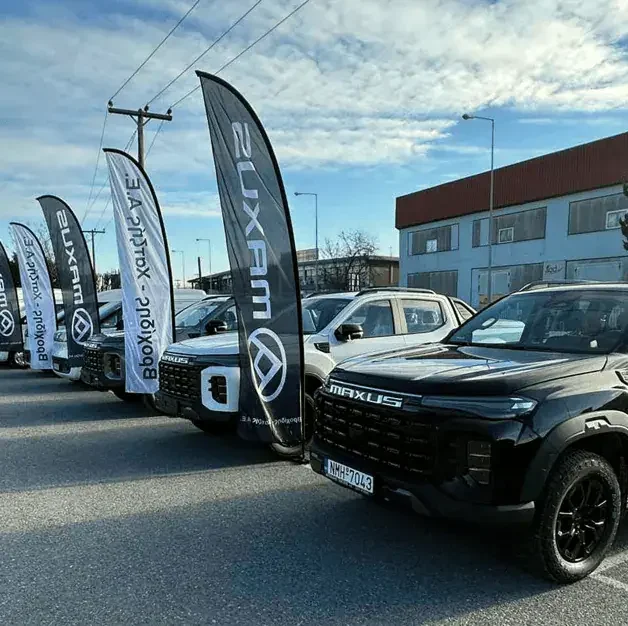 Maxus commercial vehicles displayed outdoors in a dealership lot.